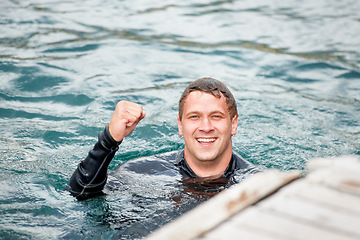 Image showing Man, lake and happy with sports, fist celebration and portrait for achievement, winning and health in summer. Person, success and emoji for goals, training or exercise with workout, river or water