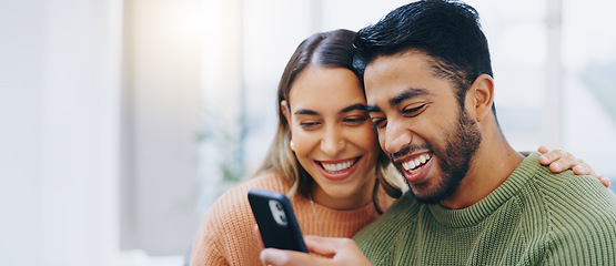 Image showing Love, hug and happy couple with phone in a house for social media, streaming or checking meme in their home together. Smartphone, app and people smile in a living room for funny gif, text or chat