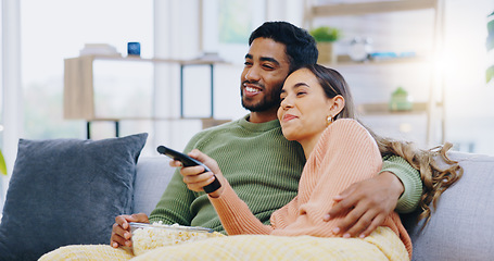 Image showing Couple, watching tv and popcorn on living room sofa for smile, hug or relax with remote for choice, show or film. Man, woman and happy together for embrace, movie or streaming on lounge couch in home