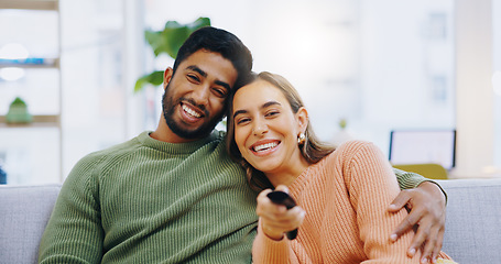 Image showing Couple, watching tv and remote on living room couch with smile, hug or relax with click for choice, show or film. Man, woman and happy together for embrace, movie or streaming on lounge sofa in home