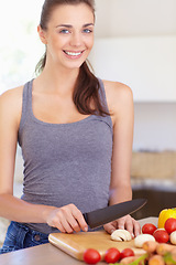 Image showing Woman, portrait and happy with knife or vegetables for nutrition, cooking or healthy meal in kitchen of home. Person, face and chopping board with mushroom, tomato and carrots for wellness and diet