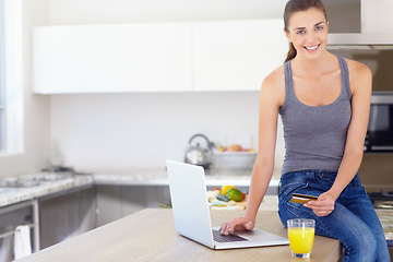 Image showing Portrait, credit card and laptop for online shopping with a woman in kitchen with orange juice in her home. Computer, smile or ecommerce with a happy young person in her apartment for finance payment