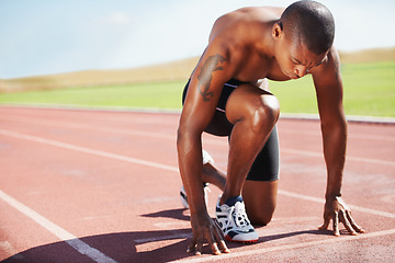 Image showing Man, athlete and ready for run on track with practice, training or workout for race. Black person, determination and concentration on face for go, speed and fast for athletics, sport and performance