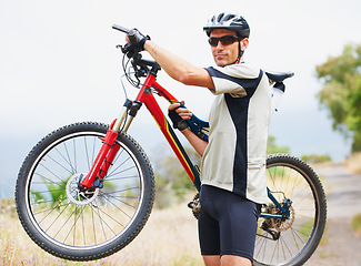 Image showing Portrait, bicycle and fitness with a man in the mountains for cardio training, recreation or summer hobby. Sports, cycling and freedom with a confident young athlete outdoor for eco friendly exercise