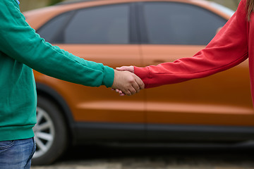 Image showing Car keys handshake, seller or car salesman and customer in a dealership, shake hands over the car keys