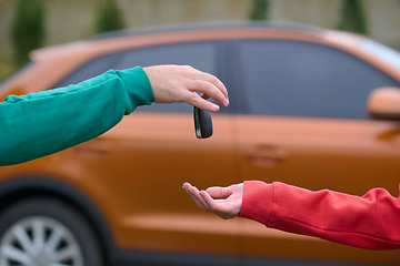 Image showing Car keys handshake, seller or car salesman and customer in a dealership, shake hands over the car keys