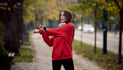 Image showing Athletic young woman taking a breath and relaxing after jogging and stretching. Woman Training and Workout Exercises On Street.