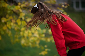 Image showing Athletic young woman taking a breath and relaxing after jogging and stretching. Woman Training and Workout Exercises On Street.