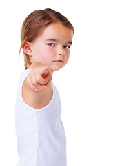 Image showing Portrait, vote and pointing with a serious child in studio isolated on a white background for choice. Kids, blame or accuse and a young girl with a gesture for decision or option on vertical space