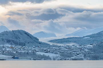 Image showing Tranquil Winter Morning Over a Snow-Covered Village by the Sea