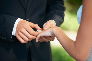 Image showing Couple, hands and wedding ring for proposal, commitment or promise in love, care or trust and support at ceremony. Closeup of married man putting jewelry on bride for loyalty, marriage or engagement