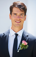 Image showing Groom man, portrait and outdoor at wedding in suit, rose and happy for celebration, event or party. Person, smile and tuxedo for choice, marriage and commitment to relationship with floral decoration