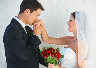 Image showing Love, happy couple and kiss on hand at wedding with smile, rose bouquet and commitment at reception. Flowers, woman and man embrace at marriage celebration with romance, loyalty and future together.
