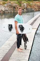 Image showing Sports, portrait and man by lake with wakeboard for surfing, exercise and recreation hobby outdoors. Fitness, extreme sport and person with board for water skiing for freedom, adventure and fun