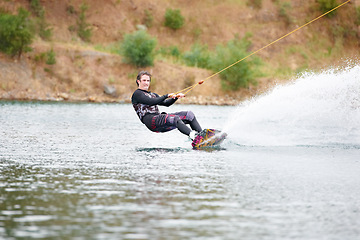 Image showing Nature, wakeboarding and adventure, man on lake with outdoor fun, fitness and wave splash. Balance, water sports and person on river with freedom, speed and energy for surfing challenge, ski and sun.