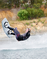 Image showing Jump, wakeboarding and adventure, man on lake with outdoor fun, fitness and wave splash. Balance, water sports and person on river with freedom, speed and energy for surfing challenge, ski and trick