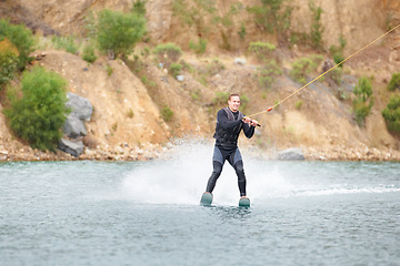 Image showing Nature, water ski and adventure, man on lake with outdoor fun, fitness and wave splash. Balance, extreme sports and person on river with freedom, speed and energy in surfing challenge, rope and spray