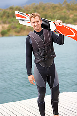 Image showing Water ski, portrait and man by lake with wakeboard for surfing, exercise and recreation hobby outdoors. Fitness, extreme sports and excited person with board for skiing for freedom, adventure and fun