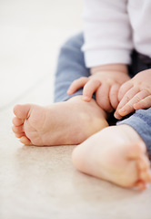 Image showing Closeup, feet and baby on floor in home for child development, health and growth. Family, youth and adorable toes and hands of young infant in living room for wellness, learning to crawl and relax