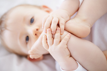 Image showing Home, bed and baby with feet playing to relax, resting and calm in nursery for sleeping or wake up in morning. Family, youth and closeup of newborn in bedroom for child development, fun and wellness