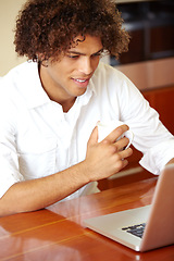 Image showing Morning, laptop and man with coffee and remote work with email in a home. Table, online job and working freelancer with social media scroll and computer with a smile from internet search in a house