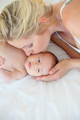 Image showing Mother, parent and baby with kiss, love and playing with care, bonding together in a bed and relax. Mom, kid and single mum in a home, happiness or nursery with child, infant and playing with family