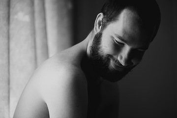 Image showing Creativity, man and smile in a bedroom at home with monochrome and black and white. Shy male person, calm thinking and art in the morning in a house with happy memory and relax with solitude