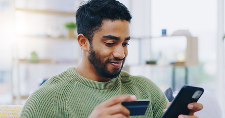 Image showing Man, credit card and phone on home sofa and online shopping with financial decision, ecommerce or sale. Person, smartphone and easy payment with click, banking or fintech on lounge couch in house