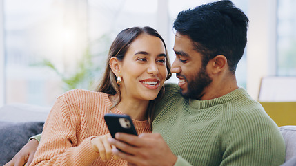 Image showing Couple, phone and smile on sofa for social media, reading notification or scroll online shopping app at home. Happy man, interracial woman or smartphone to search digital news, mobile blog or website