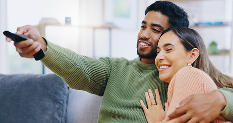 Image showing Couple, watching tv and remote on living room sofa with smile, hug or relax with click for choice, show or film. Man, woman and happy together for embrace, movie or streaming on lounge couch in home