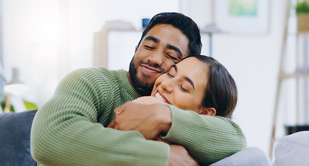 Image showing Happy, hug and couple on a sofa with love, relax and security at home bonding, hanging out or chilling. Smile, support and people in living room with trust, commitment and gratitude, care or romance