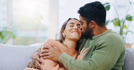 Image showing Hug, kiss and couple on a sofa with love, relax and security at home bonding, hanging out or chilling. Happy, support and people in a living room with trust, commitment and gratitude, care or romance