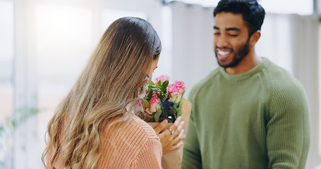 Image showing Couple, bouquet and woman gift in home, roses and smile with care, love or smell for birthday, anniversary or celebration. Man, girl and flowers for present, surprise or bonding with romance in house