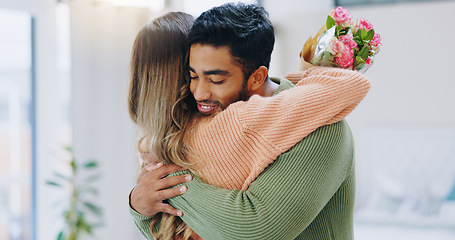 Image showing Man, woman and hug with bouquet in home with roses for smile, care or love on birthday, anniversary and event. Couple, flowers and happy for present, gift or surprise for bonding, romance or together