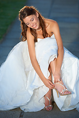 Image showing Woman, wedding and feet with bride, shoes and high heels outdoor with smile and dress for celebration. Person, designer footwear and elegance in nature for ceremony, event or happy and joy in summer