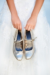 Image showing Hands, wedding and closeup of a bride with shoes and dress for luxury, elegant and romantic event. Zoom of woman with silver, fashion and bridal heels and garments marriage ceremony or celebration.