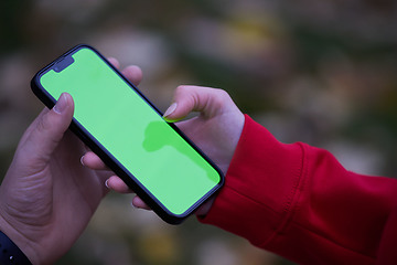 Image showing Tired fitness woman after workout and use smartphone with green screen