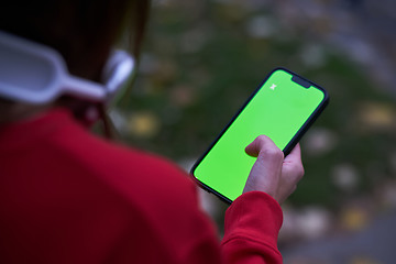 Image showing Tired fitness woman after workout and use smartphone with green screen