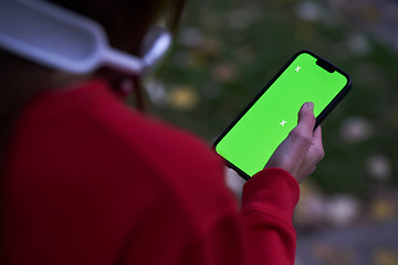 Image showing Tired fitness woman after workout and use smartphone with green screen