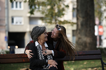 Image showing Elderly old cute woman with Alzheimer's very happy and smiling when eldest daughter hugs and takes care of her