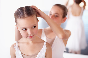 Image showing Ballet, children and help with hair in studio, academy or gym, dancer friends training together. Young girl ballerina students in dance class with support, trust and learning practice for performance