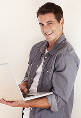 Image showing Man, laptop and portrait in studio for remote work, social media and search subscription for digital download on white background. Happy freelancer, computer and blog connection for online shopping