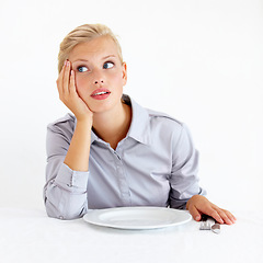 Image showing Bored, upset and woman with a plate in a studio with starving, frustrated and grumpy face. Angry, hungry and young female person from Australia with dish and cutlery isolated by white background.