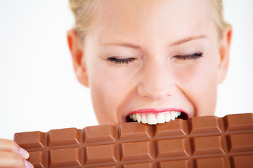 Image showing Studio face, woman or eating chocolate bar, delicious snack or candy for unhealthy food, dessert or sugar product. Diet craving, calories or girl bite, taste or enjoy cacao sweets on white background