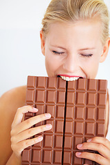 Image showing Eating woman, hungry and bite chocolate bar, delicious snack or candy for studio food, dessert or sugar craving. Diet cheat meal calories, diabetes or girl hunger for cacao sweets on white background