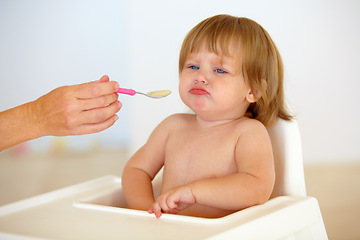 Image showing Baby, chair and eating food or unhappy mood for health meal, childhood development or upset. Hand, spoon and feed seat or tired fail kid for dinner or disappointed face or distress, care or problem