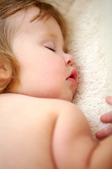 Image showing Closeup, baby and face for sleeping in nursery on bed for good dream, nap or rest. Toddler, little girl and relaxing on pillow for child growth with love, care and support for , cognitive development