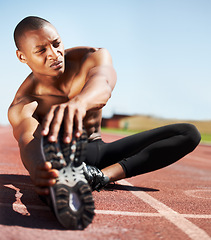 Image showing Man, training and stretching leg on ground, outdoors and fitness for health, sports and performance. Black male person, athlete and warmup on track, workout and commitment or ready, floor and cardio