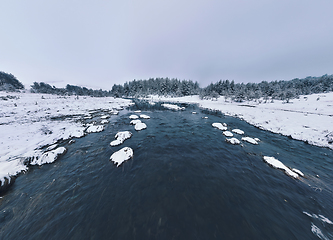 Image showing Amazing Cinematic Aerial View On Freezing River. Aerial View Flight Above Frozen Creek Scenic View Of Nature