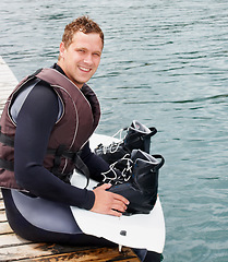 Image showing Lake, fitness and portrait of man with wakeboard for surfing, exercise and recreation hobby outdoors. Equipment, extreme sports and person with board for water skiing for freedom, adventure and fun